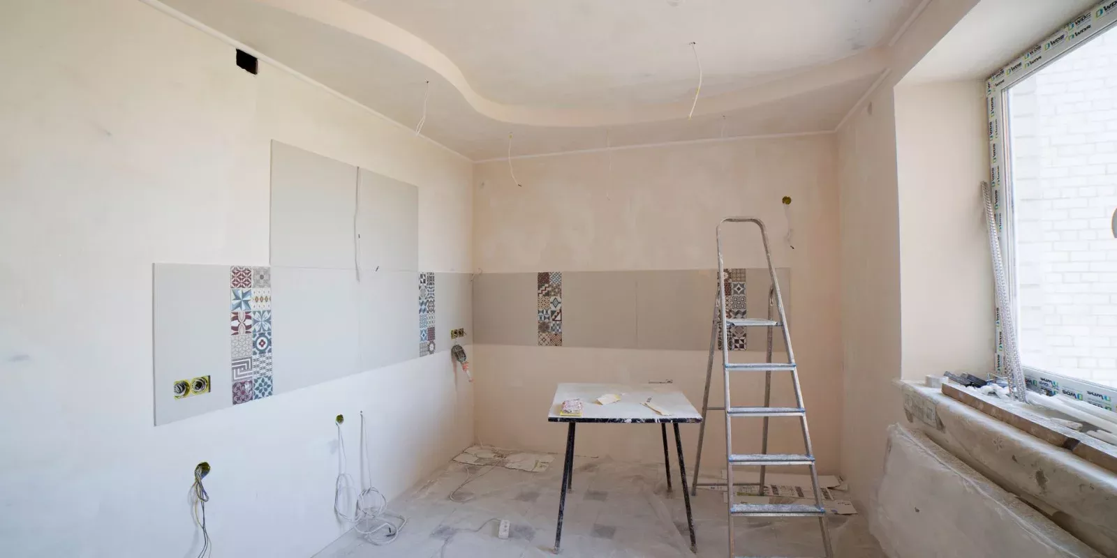 Cocina de una vivienda en obra de renovación con escalera y herramientas