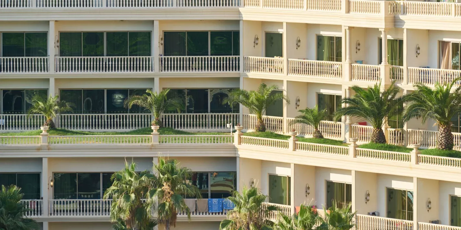 Fachada de un edificio de apartamentos con balcones y palmeras