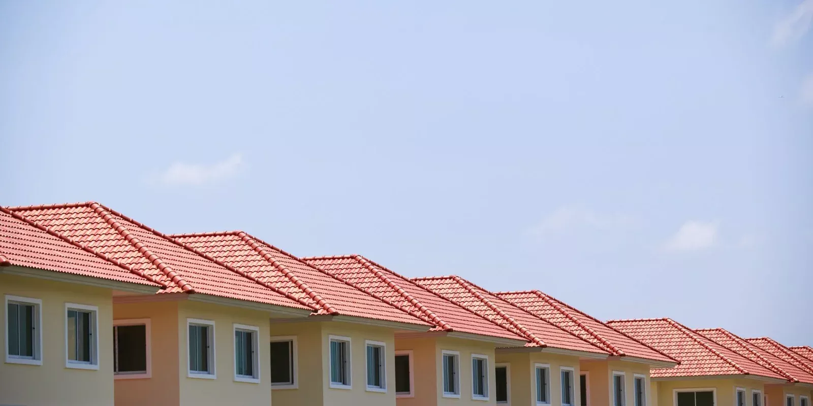 Fila de casas nuevas de techo de tejas en una comunidad residencial bajo cielo despejado