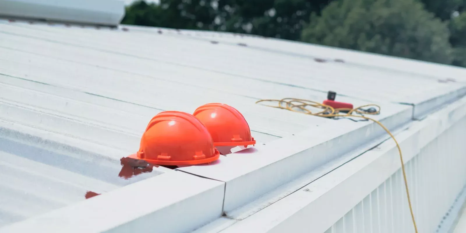 Cascos y equipo de seguridad apoyados sobre el techo de una vivienda en reparación